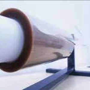 Рулон полупрозрачной янтарной плёнки на металлической подставке