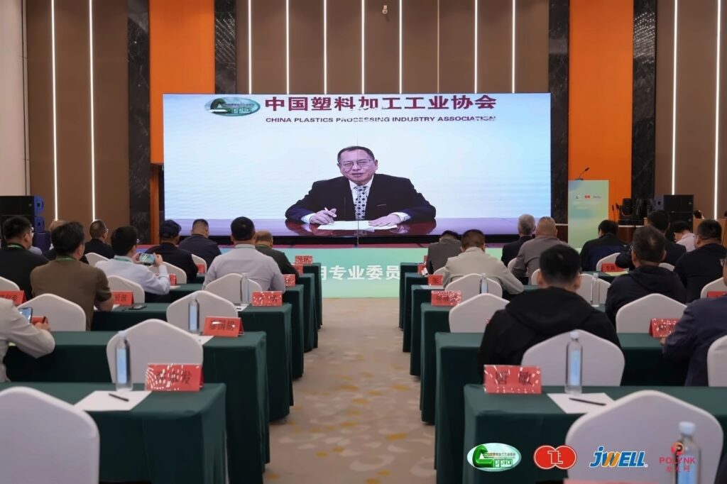 Attendees in the conference hall watching a China Plastics Processing Industry Association address on screen