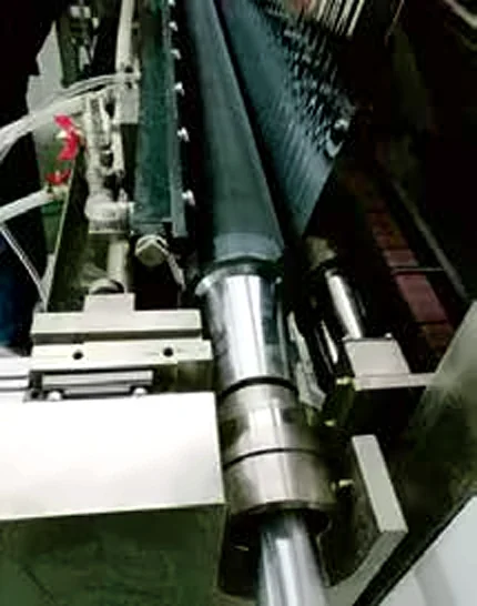 Close-up of coating die and roller assembly with thin film between them